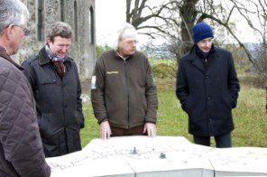In the shadow of the former Wollseifen churches, Hartmut Cremer (from right), board member KSK, Henning Walter, head of the national park administration, Manfred Poth, general representative district administrator and chairman of the supervisory board of the Vogelsang site development company, look at the model of the former Wollseifen village. Picture: Tameer Gunnar Eden/Eifeler Presse Agentur/epa